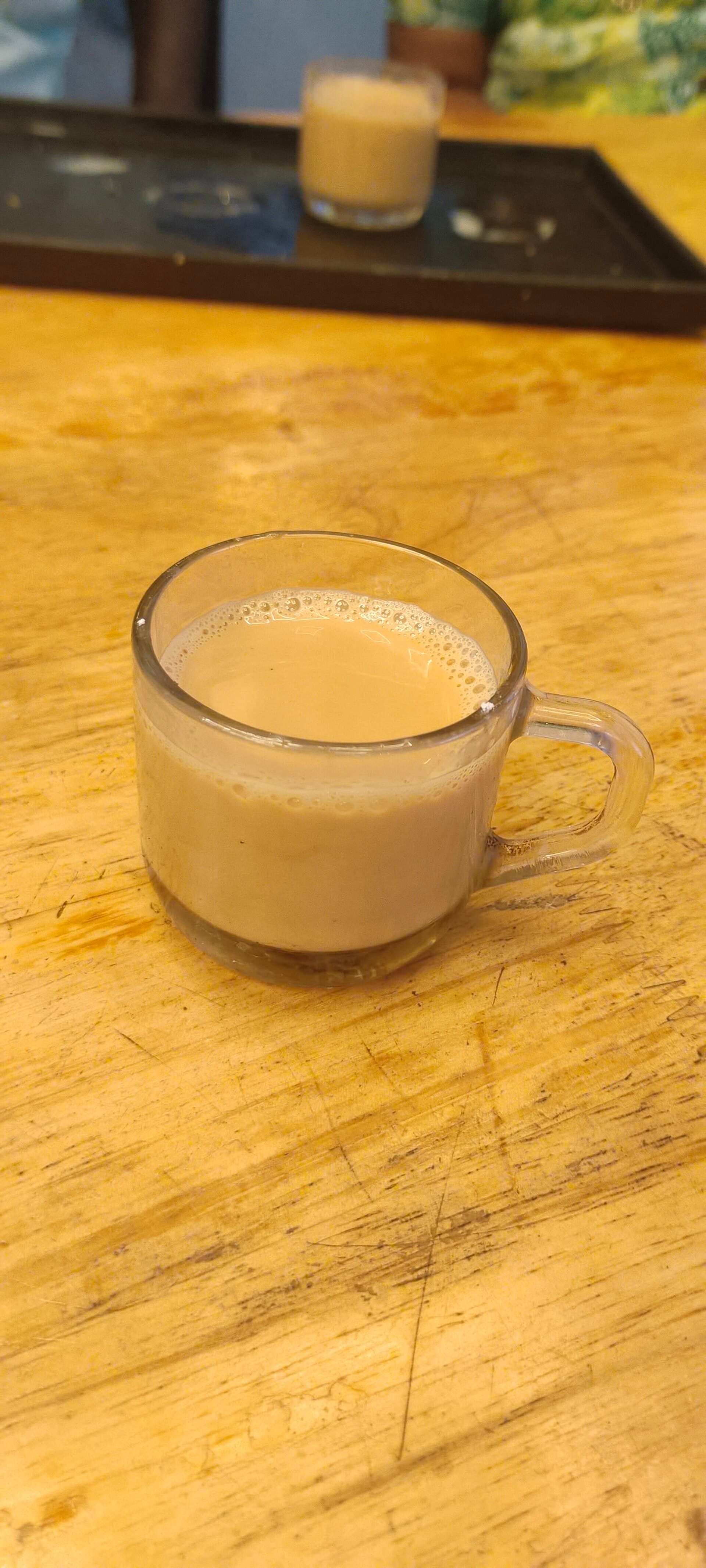 A glass cup of milk tea on a wooden table